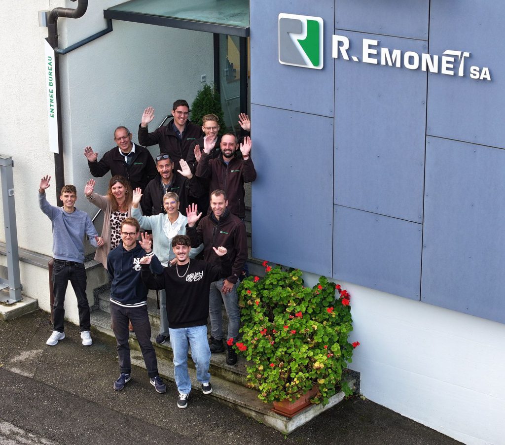 The R. Emonet SA team waving in front of the office entrance
