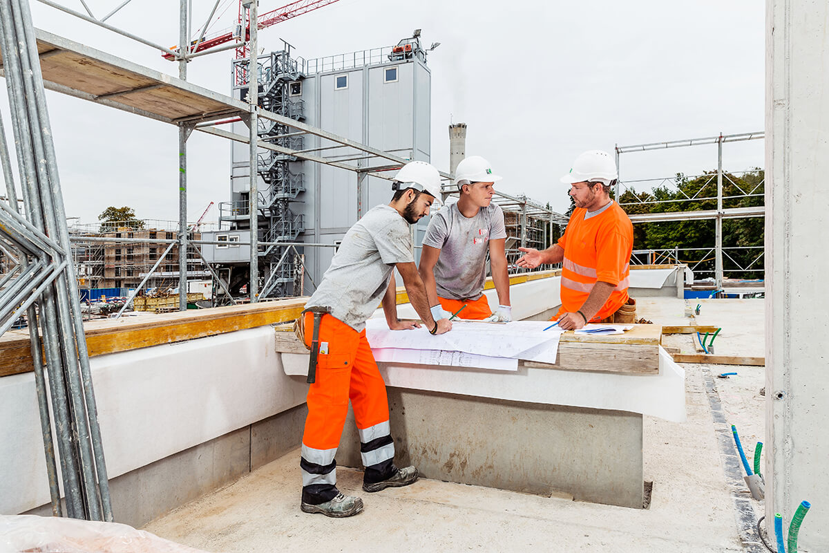 Contremaître et ouvriers consultant les plans sur un chantier