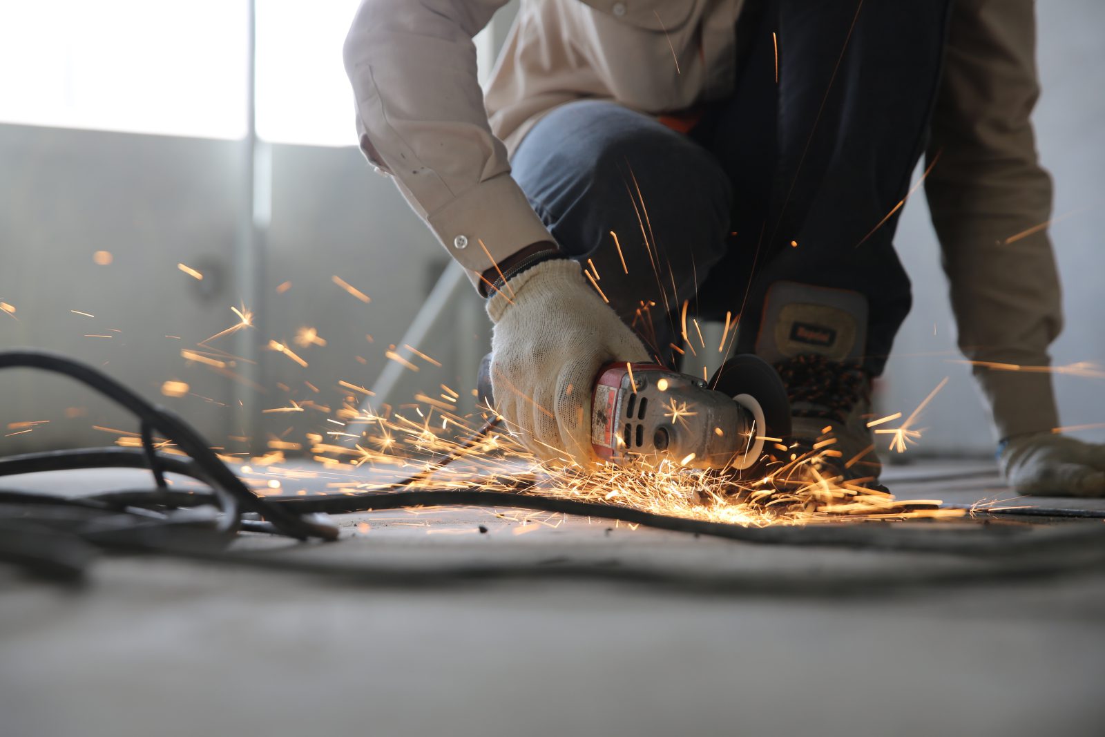 Maçon découpant à la meuleuse sur un chantier